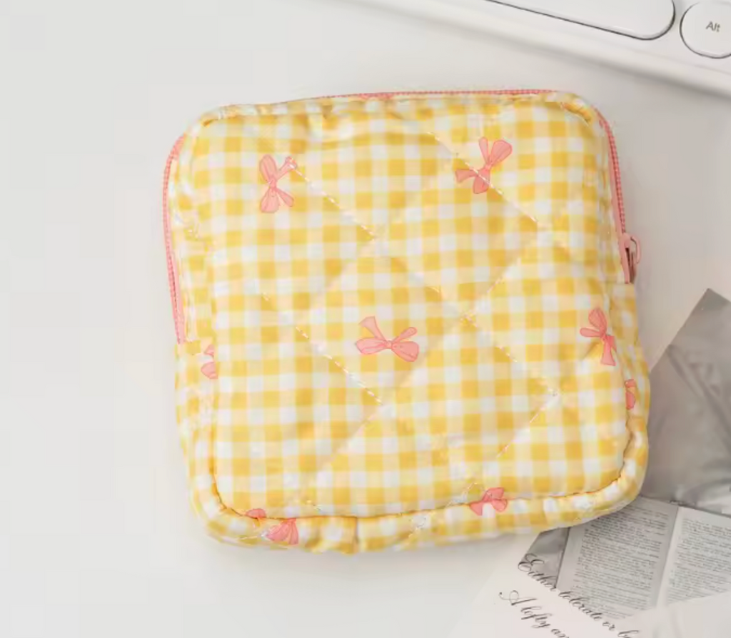 Gult rutigt väska med rosa rosetter, mjukt tygmaterial, liten storlek, används för förvaring av små personliga saker, med rosa dragkedja